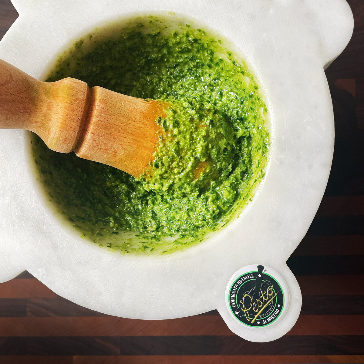 Basil pesto being made in a pestle and mortar